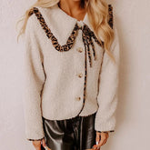White fluffy cardigan with leopard print trim worn by a person.